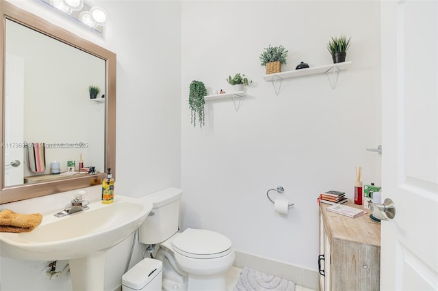 1110 Canella Ln, Hollywood, FL 33019 - half bathroom featuring toilet, baseboards, tile patterned floors, and a sink