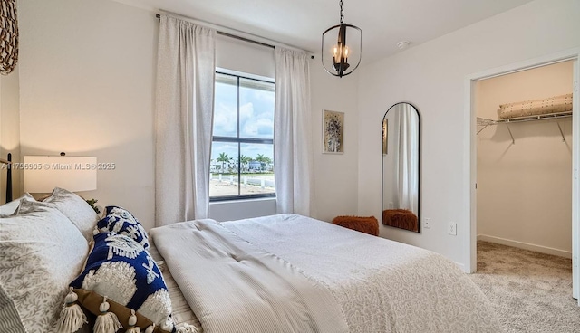 bedroom with carpet, a closet, baseboards, and a spacious closet