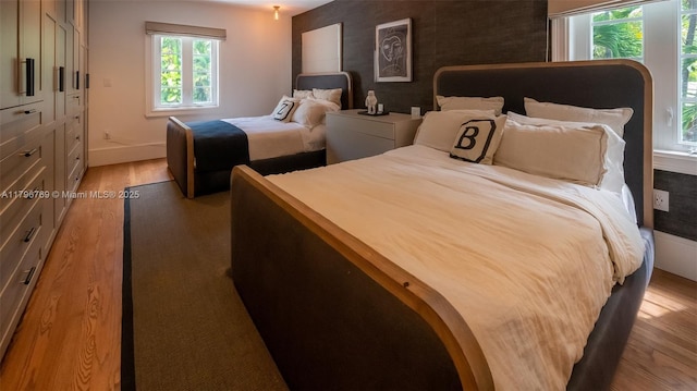 bedroom with light wood-type flooring and baseboards