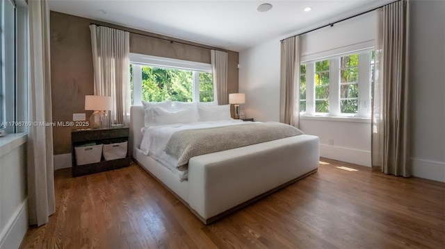 bedroom featuring wood finished floors and multiple windows