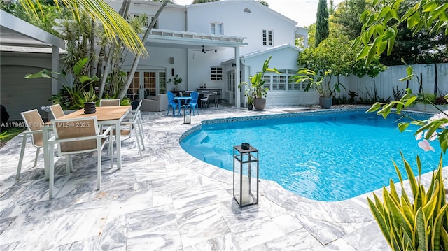 view of swimming pool with a patio area, fence, a fenced in pool, a ceiling fan, and outdoor dining area
