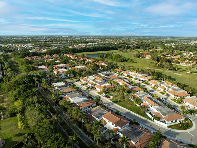 drone / aerial view featuring a water view, golf course view, and a residential view
