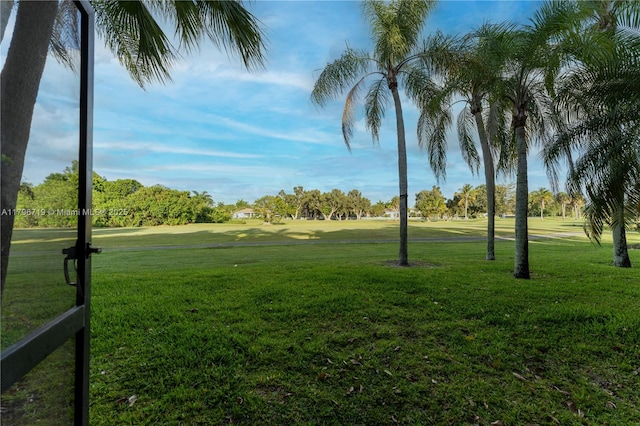 view of property's community featuring golf course view and a lawn