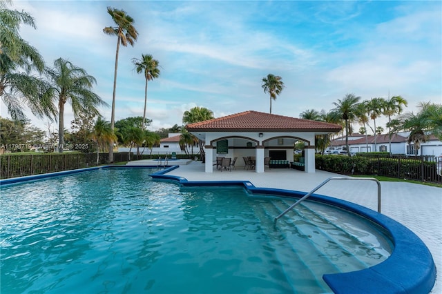 community pool featuring a gazebo, fence, and a patio