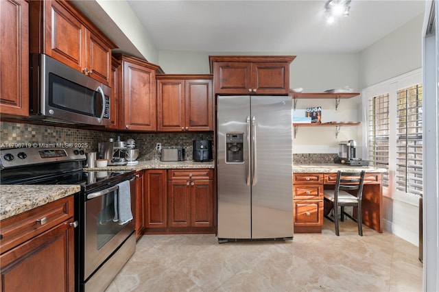 kitchen with light stone counters, stainless steel appliances, open shelves, and decorative backsplash
