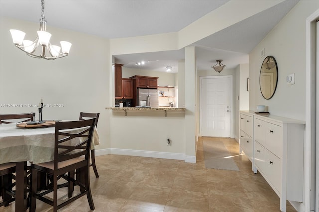 dining room with a chandelier and baseboards