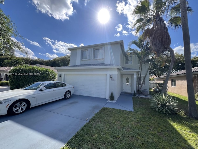 traditional-style home featuring concrete driveway, stucco siding, a garage, and a front lawn
