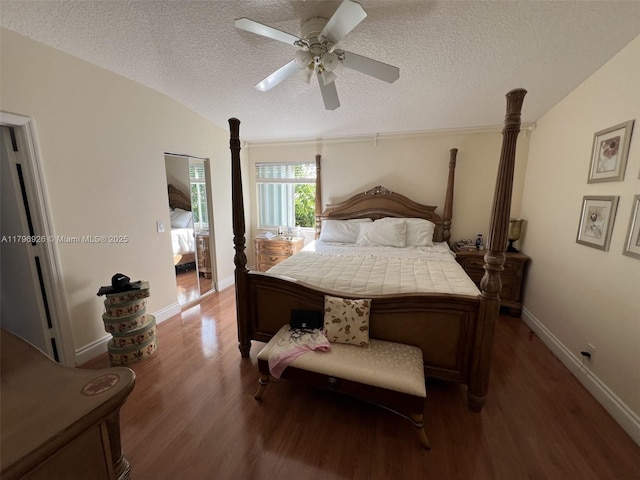 bedroom with a textured ceiling, baseboards, a ceiling fan, and wood finished floors