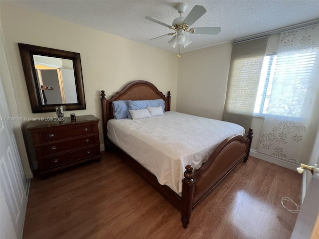bedroom featuring baseboards, a ceiling fan, a textured ceiling, and dark wood-type flooring