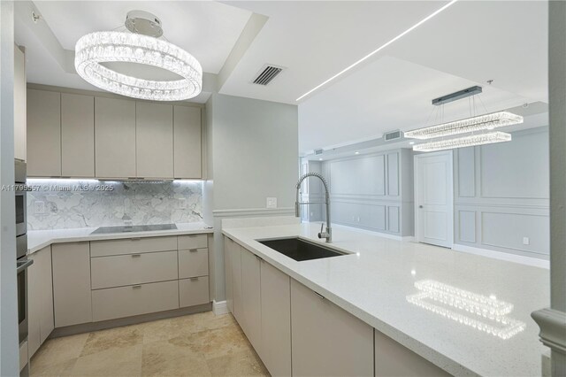 3400 SW 27th Ave Unit 1506, Miami, FL 33133 - kitchen featuring an inviting chandelier, a sink, visible vents, tasteful backsplash, and black electric stovetop