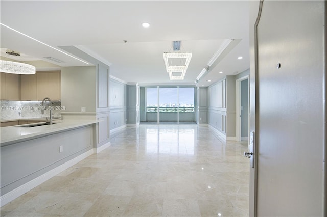 3400 SW 27th Ave Unit 1506, Miami, FL 33133 - empty room featuring a sink, a chandelier, ornamental molding, and a decorative wall