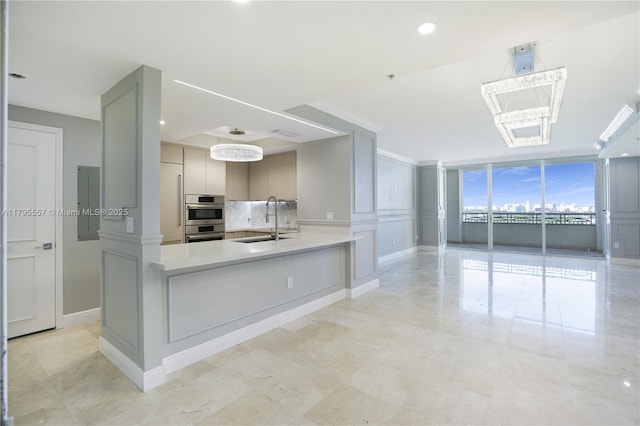 3400 SW 27th Ave Unit 1506, Miami, FL 33133 - kitchen with a sink, backsplash, light countertops, and baseboards