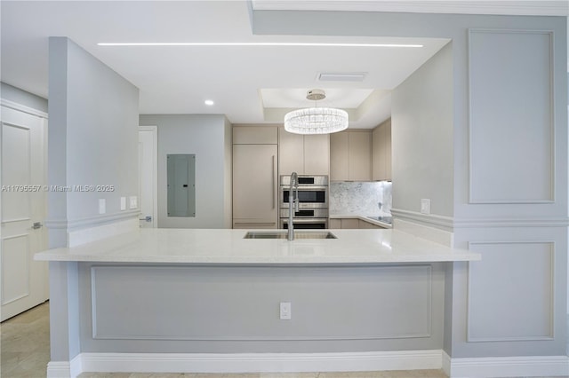 3400 SW 27th Ave Unit 1506, Miami, FL 33133 - kitchen featuring a notable chandelier, a peninsula, decorative backsplash, electric panel, and light countertops