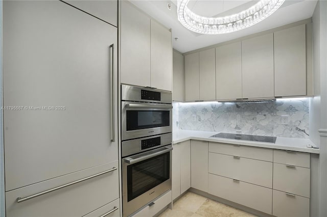 3400 SW 27th Ave Unit 1506, Miami, FL 33133 - kitchen with double oven, decorative backsplash, black electric stovetop, light countertops, and gray cabinets