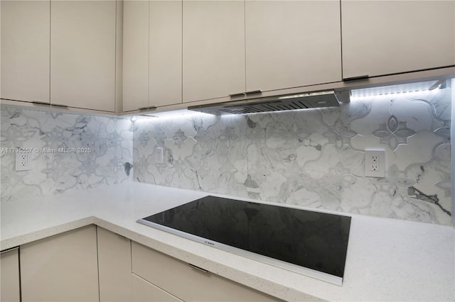 3400 SW 27th Ave Unit 1506, Miami, FL 33133 - room details with black electric cooktop, under cabinet range hood, light stone counters, and decorative backsplash