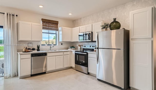 kitchen with a sink, white cabinetry, light countertops, and appliances with stainless steel finishes