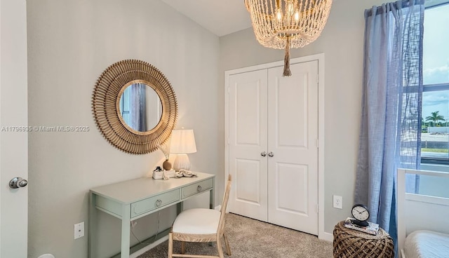 home office with light colored carpet and a notable chandelier