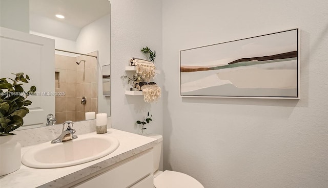 bathroom featuring toilet, a shower, and vanity