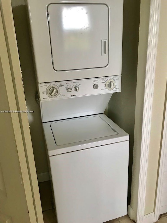 washroom with stacked washing maching and dryer and laundry area