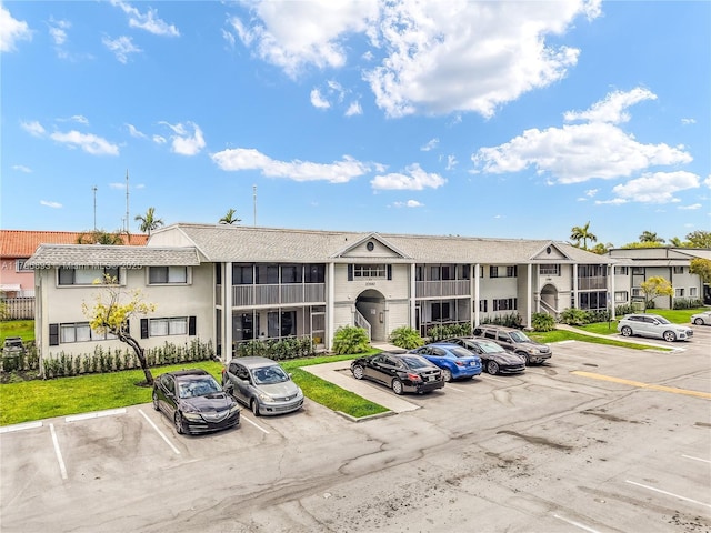 view of property with uncovered parking and a residential view