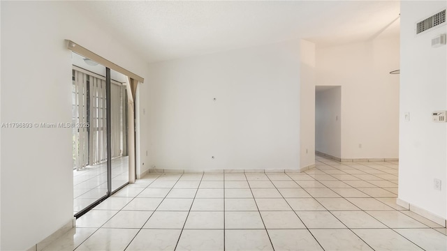 empty room with baseboards, light tile patterned floors, and visible vents