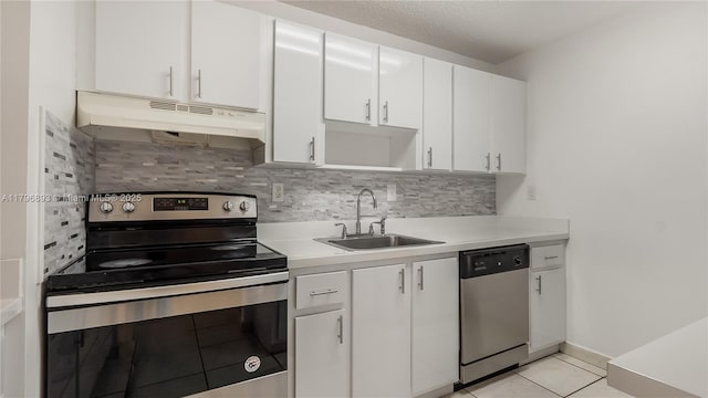 20680 NE 4th Ct Unit 206, Miami, FL 33179 - kitchen featuring under cabinet range hood, a sink, white cabinetry, tasteful backsplash, and appliances with stainless steel finishes
