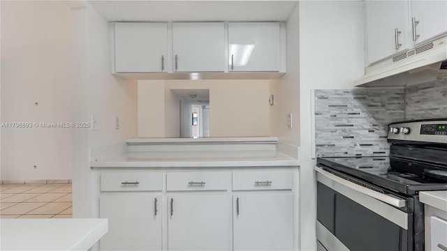 20680 NE 4th Ct Unit 206, Miami, FL 33179 - kitchen with stainless steel electric range, white cabinetry, backsplash, under cabinet range hood, and light countertops