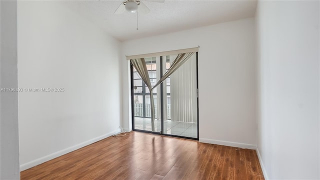 empty room featuring baseboards, a ceiling fan, and wood finished floors