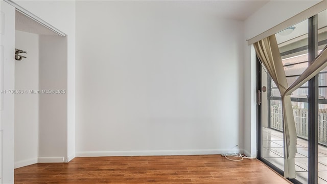 unfurnished room featuring wood finished floors and baseboards
