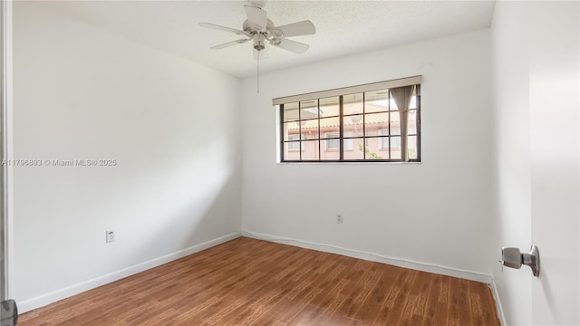 empty room with ceiling fan, baseboards, and wood finished floors