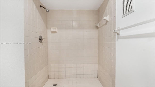 bathroom with a shower stall and visible vents