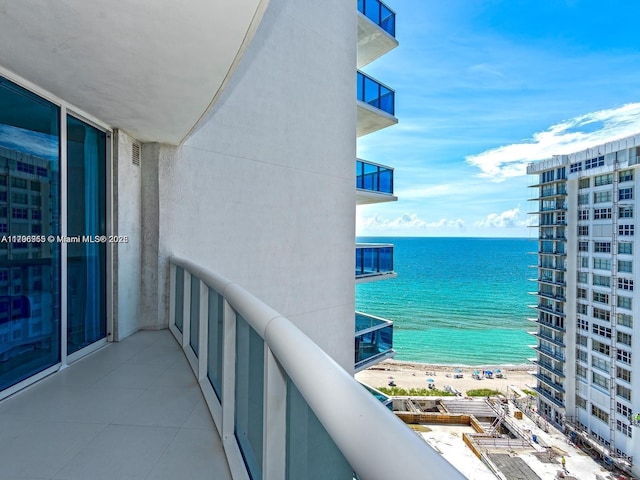 balcony with a water view and a beach view