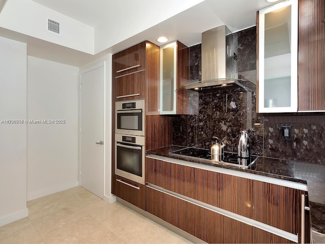 kitchen featuring wall chimney range hood, modern cabinets, black electric stovetop, and backsplash