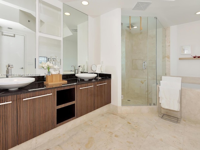 full bathroom featuring recessed lighting, double vanity, a shower stall, and a sink