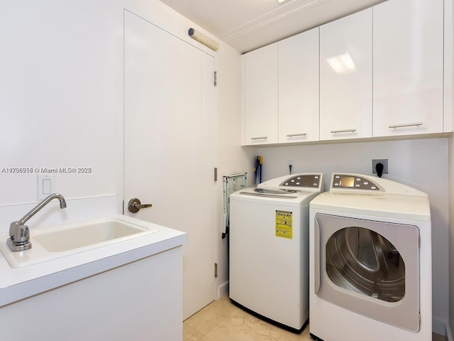 washroom featuring a sink, cabinet space, and independent washer and dryer
