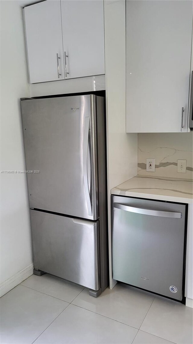 3401 N Country Club Dr Unit 410, Aventura, FL 33180 - kitchen with white cabinets, light countertops, light tile patterned floors, and stainless steel appliances