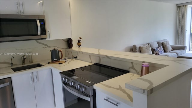 3401 N Country Club Dr Unit 410, Aventura, FL 33180 - kitchen featuring white cabinetry, tasteful backsplash, appliances with stainless steel finishes, and a sink