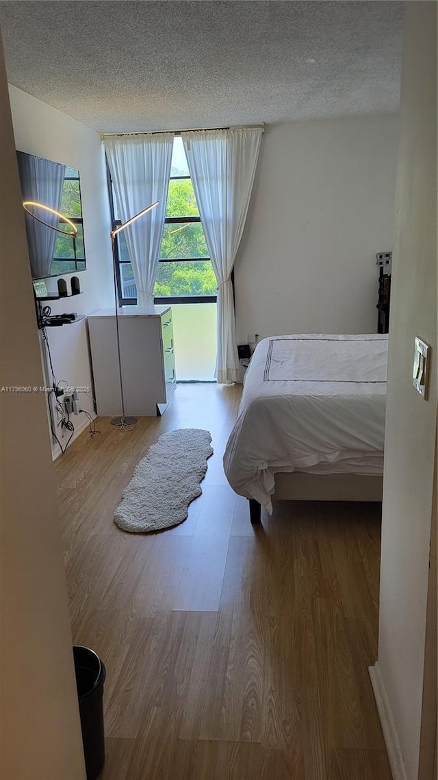 3401 N Country Club Dr Unit 410, Aventura, FL 33180 - bedroom featuring a textured ceiling and wood finished floors