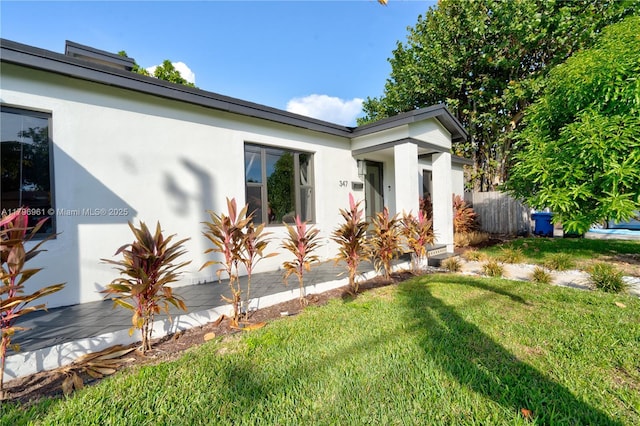 view of front of home with a front yard and stucco siding