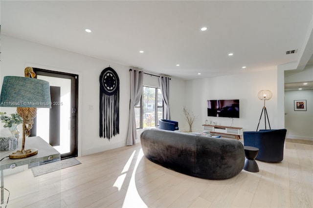 living area featuring light wood finished floors, visible vents, and recessed lighting