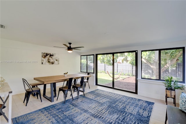 dining room with baseboards, a ceiling fan, and visible vents
