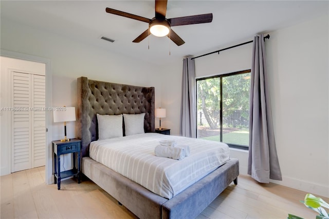 bedroom with a ceiling fan, baseboards, light wood finished floors, and visible vents