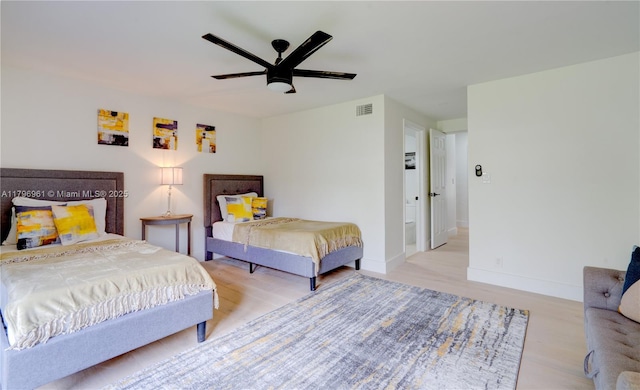 bedroom featuring light wood finished floors, baseboards, a ceiling fan, and visible vents