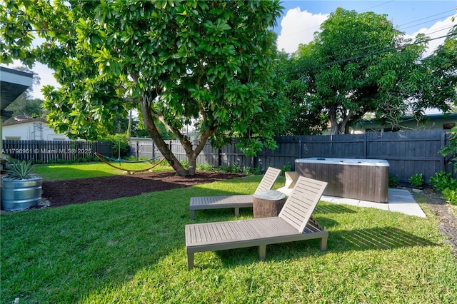 view of yard with a hot tub and a fenced backyard