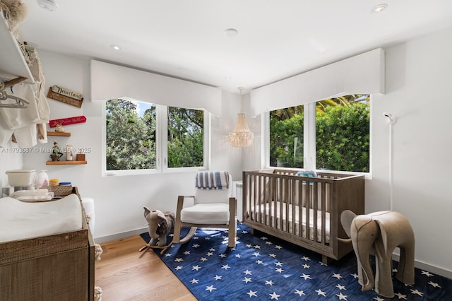 bedroom with wood finished floors, baseboards, and recessed lighting
