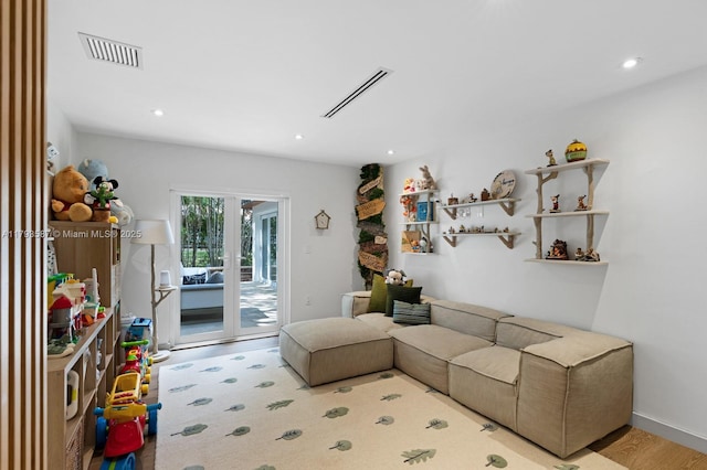 living area with wood finished floors, visible vents, and recessed lighting
