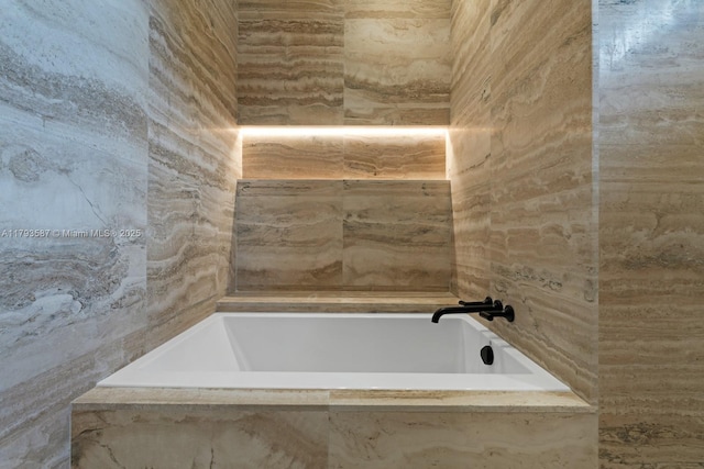 full bath featuring a tub with marble appearance