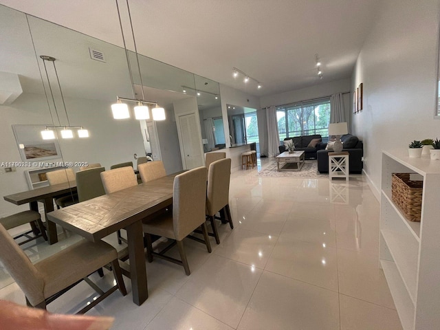 dining space with baseboards, light tile patterned floors, and visible vents
