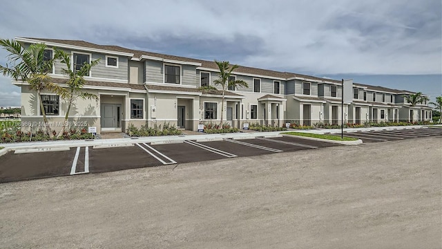 view of building exterior featuring a residential view and uncovered parking
