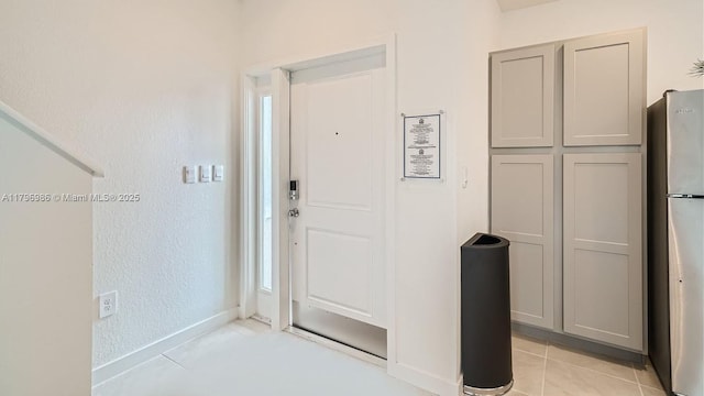 entryway with light tile patterned floors and baseboards
